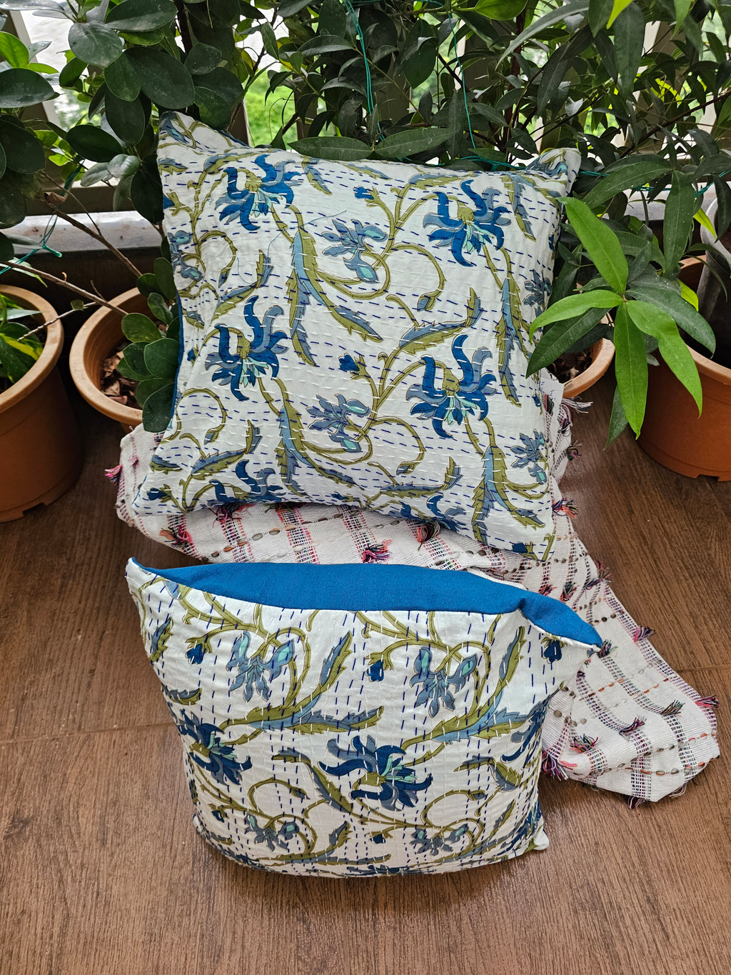 Decorative pillows with floral patterns on a wooden surface