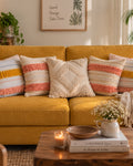 Set of 5 boho-style cotton cushion covers, featuring two end pillows with peach, blue, and yellow fringe stripes, two inner pillows with peach tufted stripes, and a central cream pillow with a raised diamond tufted pattern, arranged neatly on a mustard yellow sofa in a living room setting.