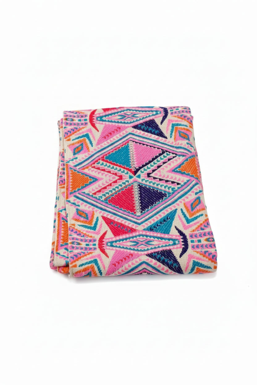 Bright Aztec geometric woven cotton table runner with pink, blue, and orange diamond pattern on a dining table