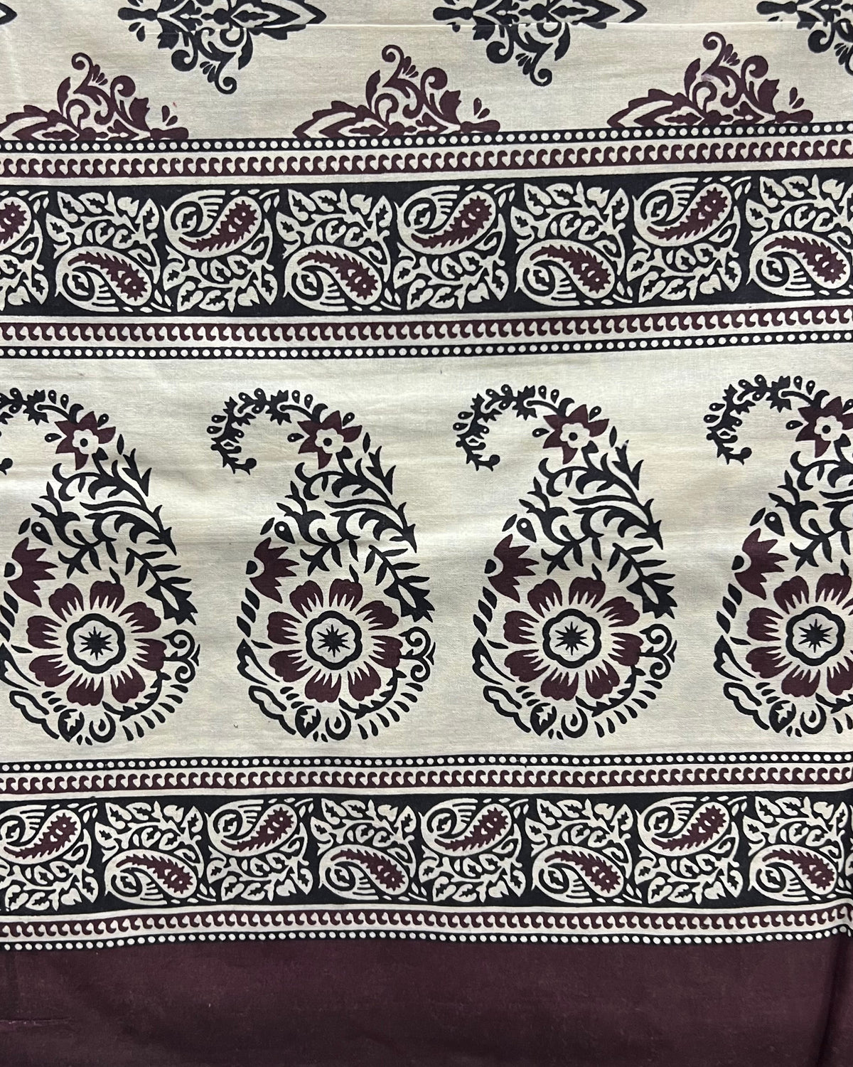 Brown and cream cotton bed sheet featuring a traditional block-printed paisley and floral pattern with coordinating border details.
