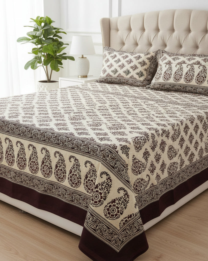 Brown and cream cotton bed sheet featuring a traditional block-printed paisley and floral pattern with coordinating border details.