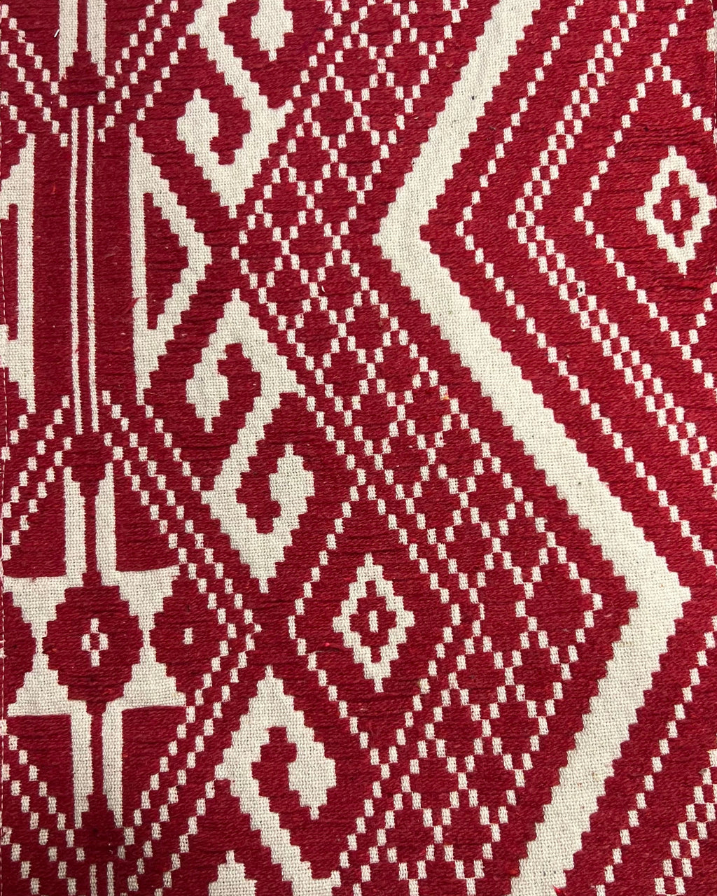 Crimson red and cream geometric jacquard cotton placemat featuring an intricate woven Aztec and diamond pattern.