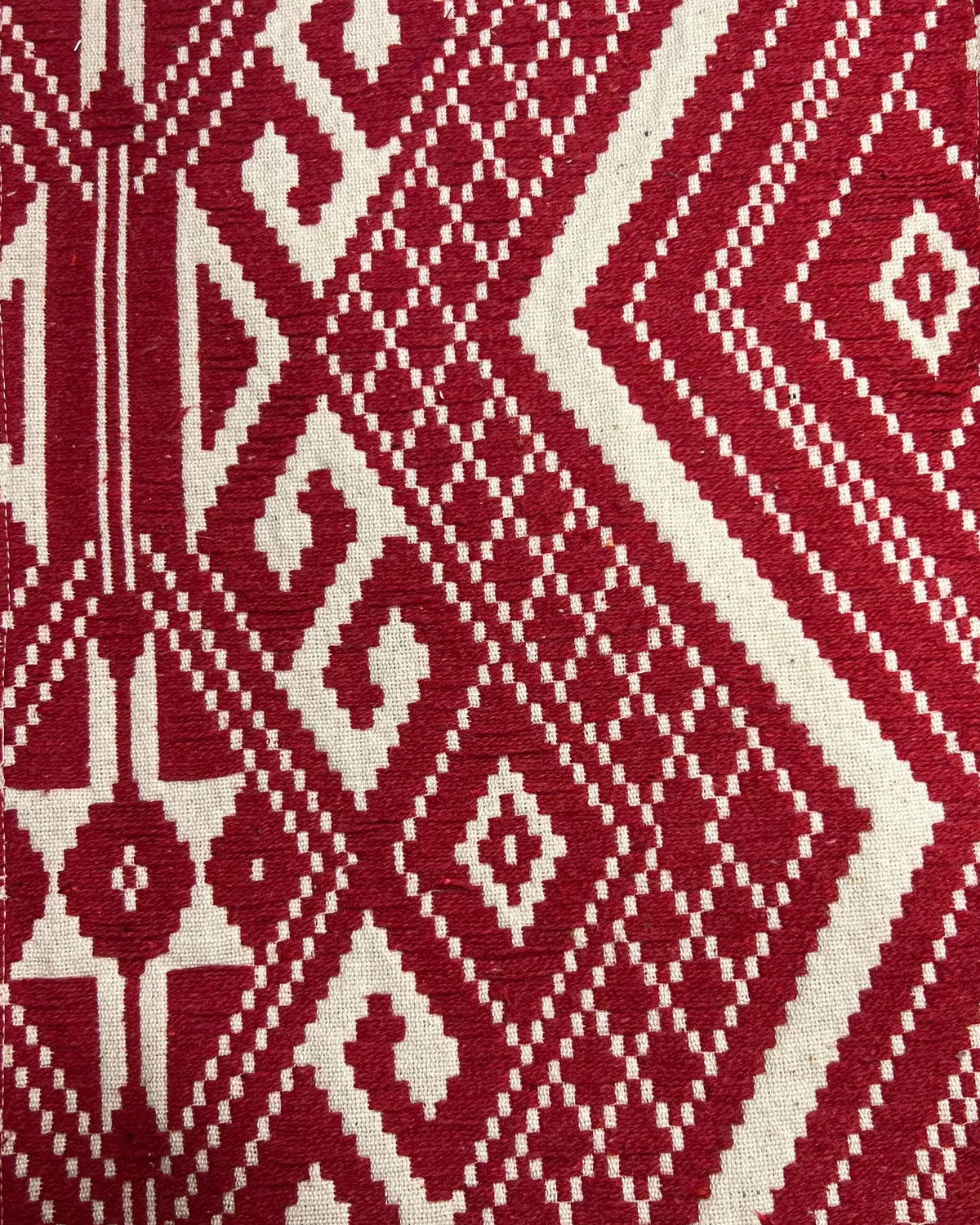 Crimson red and cream geometric jacquard cotton placemat featuring an intricate woven Aztec and diamond pattern.