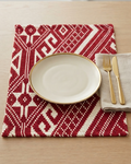 Crimson red and cream geometric jacquard cotton placemat featuring an intricate woven Aztec and diamond pattern.