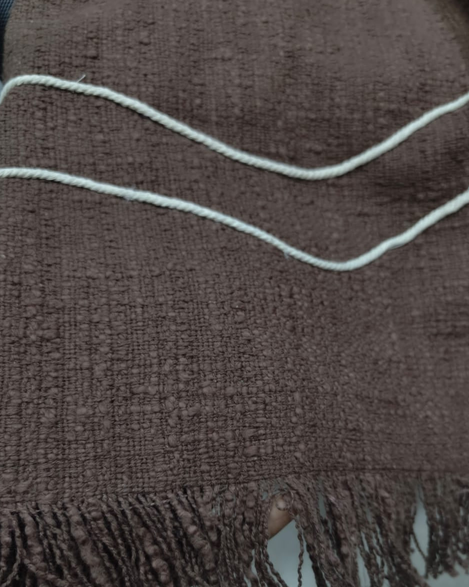 Dark chocolate brown cotton sofa cover with off-white embroidered wavy accent lines and fringed hem styled across a mustard yellow sofa seating area.