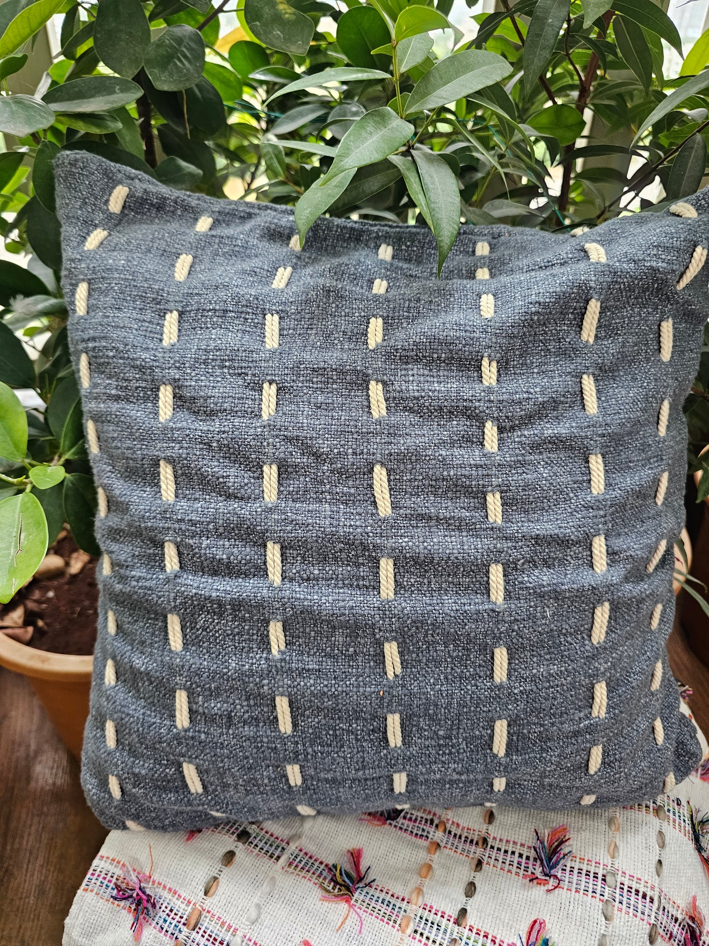 dark grey cushion cover with delicate white embroidery