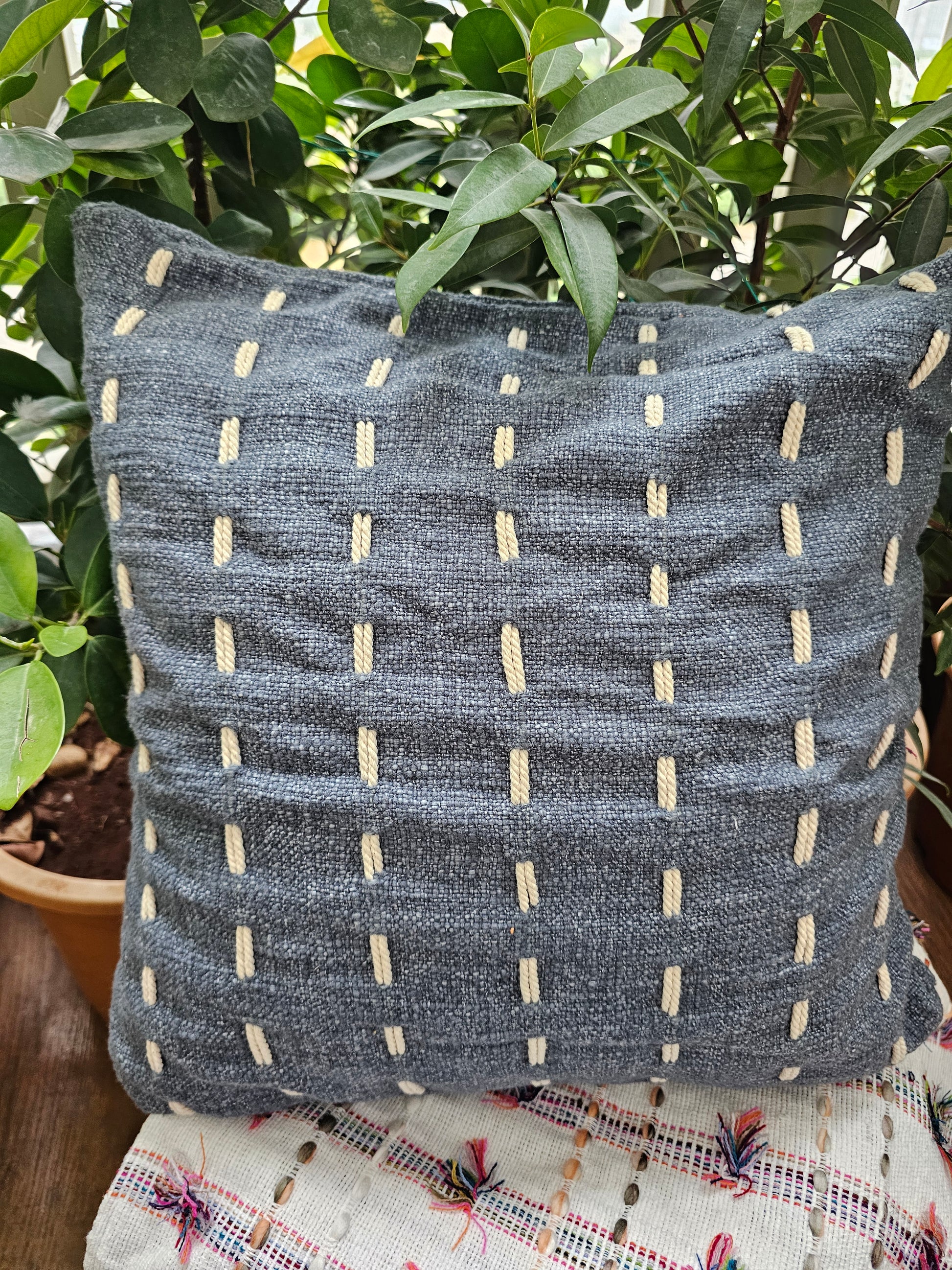 dark grey cushion cover with delicate white embroidery