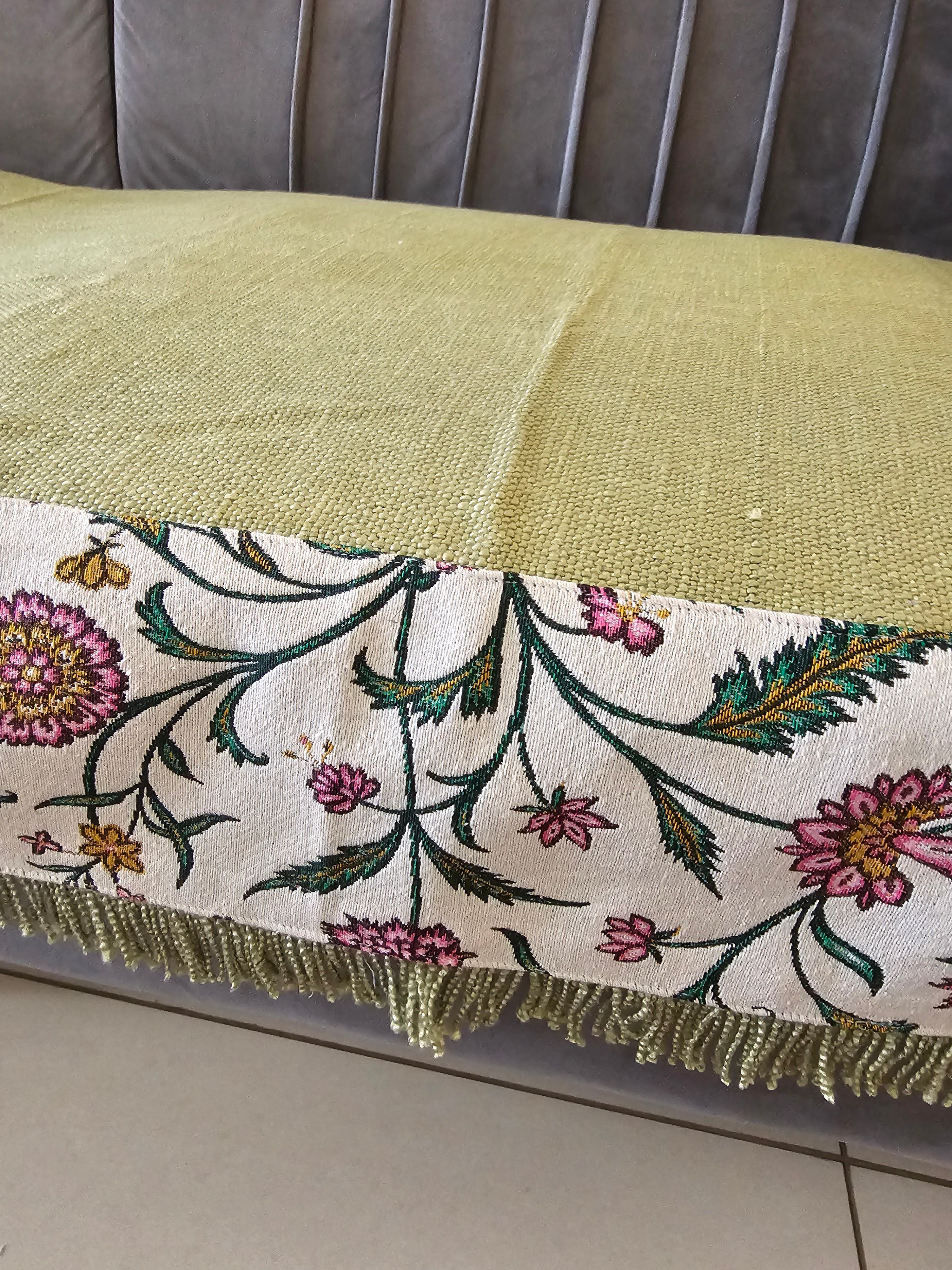 Decorative fabric with floral patterns and gold trim on a neutral background