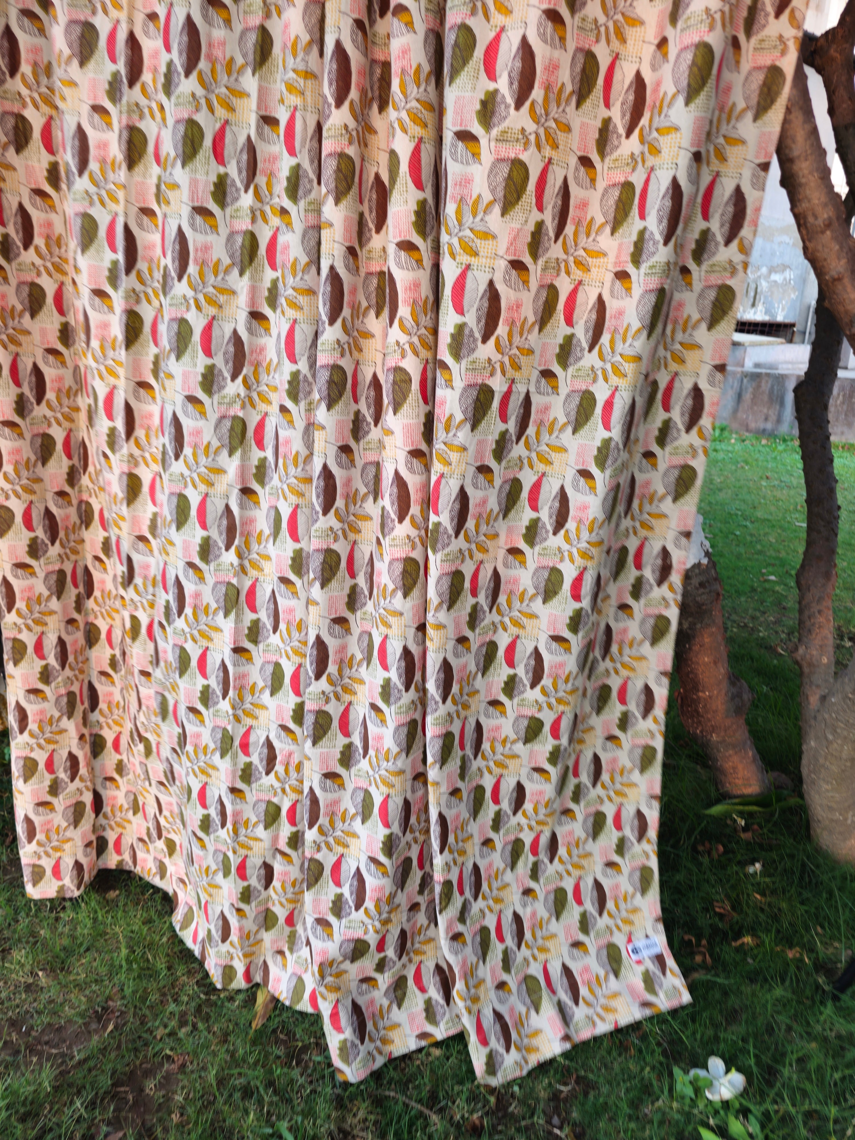 Patterned curtain draped over a tree branch outdoors