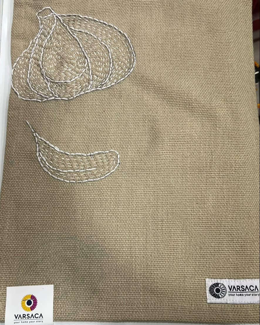 Hand-embroidered garlic bulb and clove motif on a natural textured burlap-style cotton placemat.