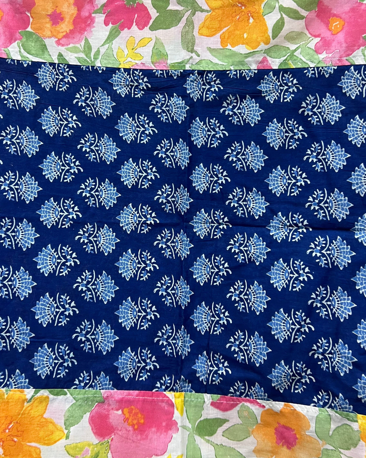 Cotton table cover featuring vibrant watercolor floral panels flanking a contrasting central band of traditional indigo blue block-printing.