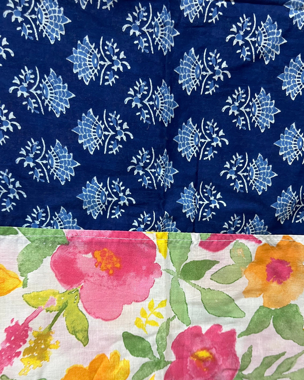 Cotton table cover featuring vibrant watercolor floral panels flanking a contrasting central band of traditional indigo blue block-printing.