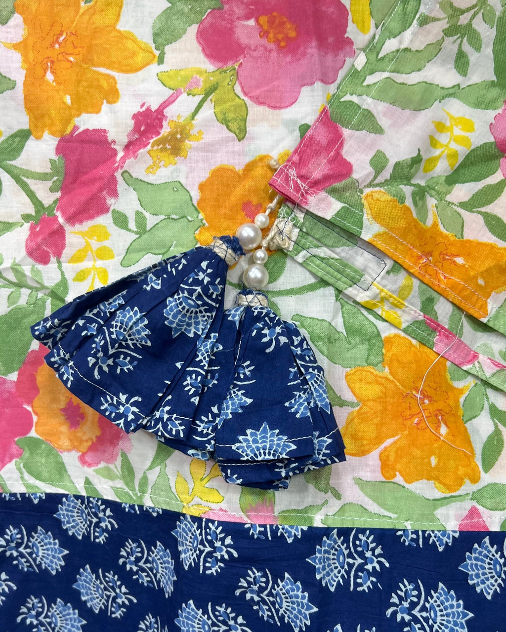 Cotton table cover featuring vibrant watercolor floral panels flanking a contrasting central band of traditional indigo blue block-printing.