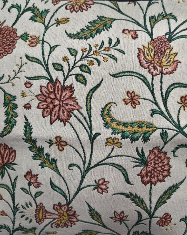 Square cream cotton cushion cover featuring a woven jacquard botanical vine pattern with rose-pink flowers and green leaves.