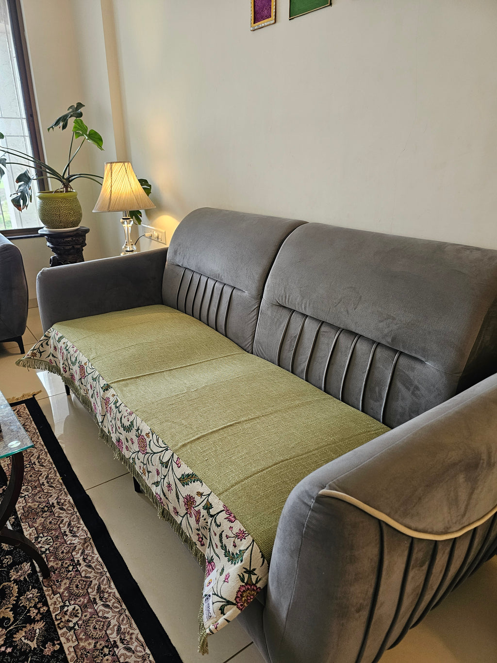 Gray sofa with a floral-patterned throw blanket in a living room setting.