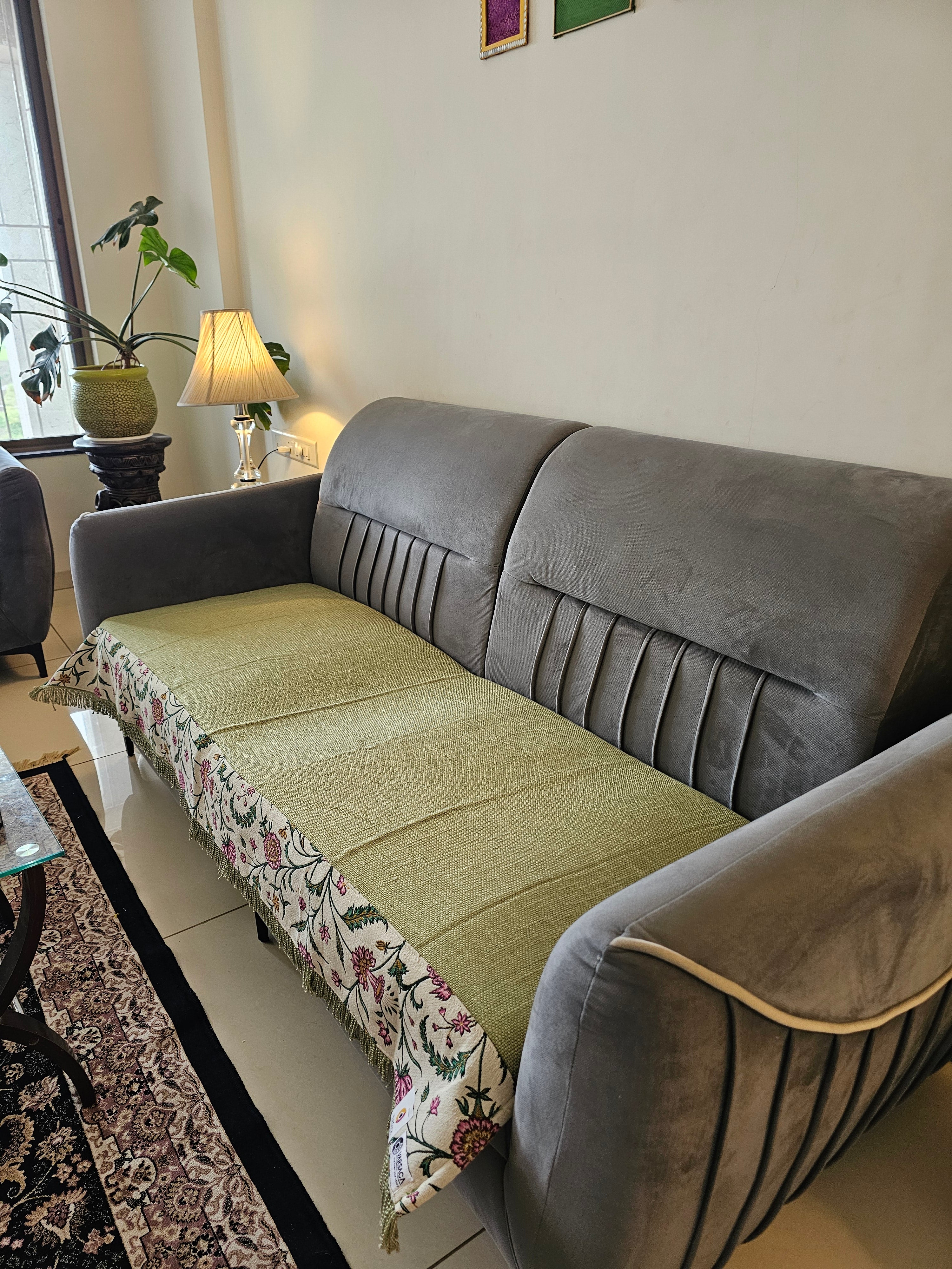 Gray sofa with a floral-patterned throw blanket in a living room setting.