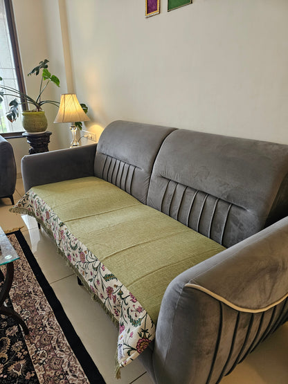 Gray sofa with a floral-patterned throw blanket in a living room setting.