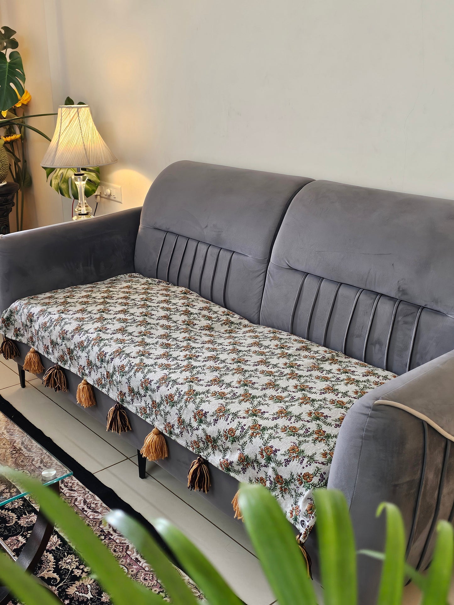 Gray sofa with a patterned cushion and decorative items on a shelf.
