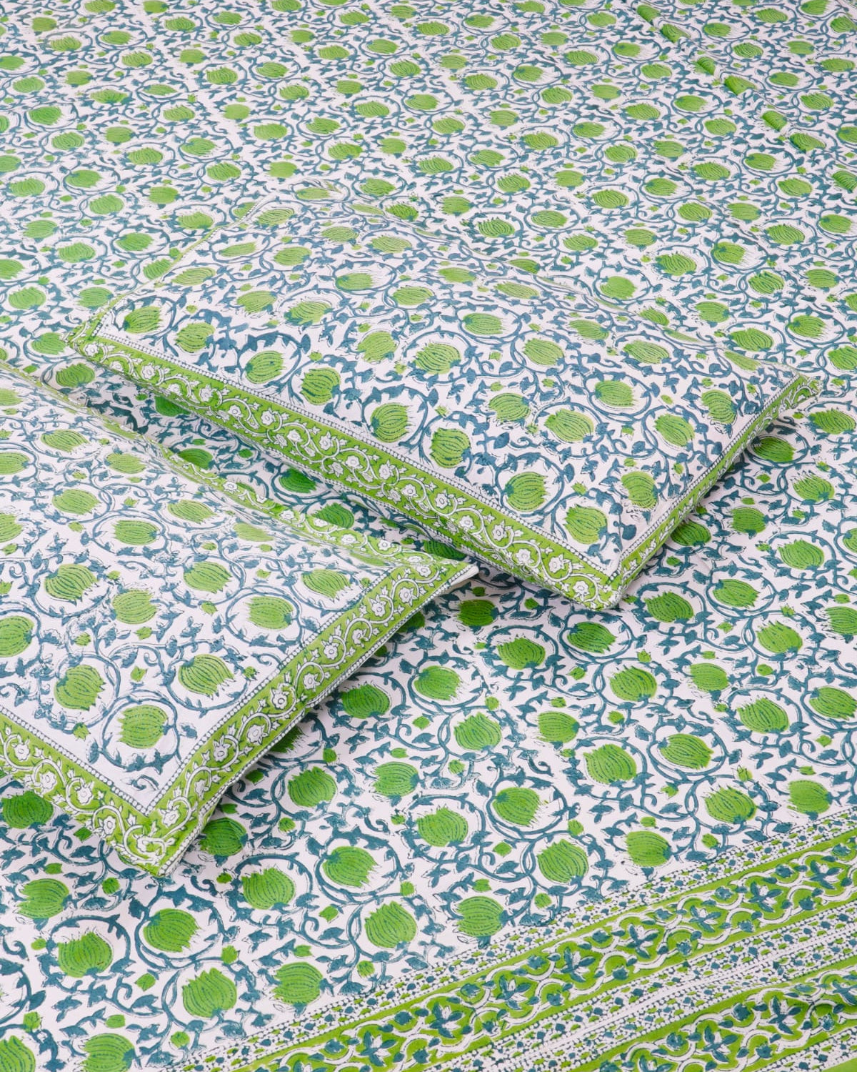 100x108 inch king size cotton bedsheet and matching green-bordered pillow covers styled with a traditional green and blue floral bud handblock print.