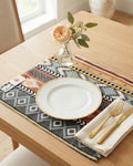 Geometric bohemian jacquard cotton placemat featuring a woven Aztec stripe and diamond pattern in rust orange, mustard, and slate gray.