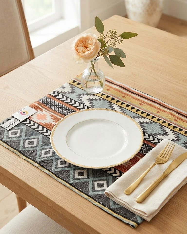 Geometric bohemian jacquard cotton placemat featuring a woven Aztec stripe and diamond pattern in rust orange, mustard, and slate gray.