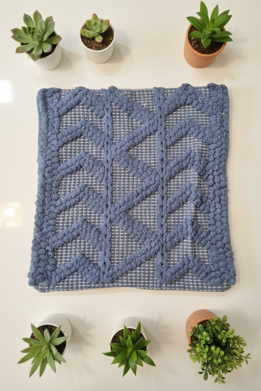 Blue textured rug on a white surface with a person wearing red pants partially visible.