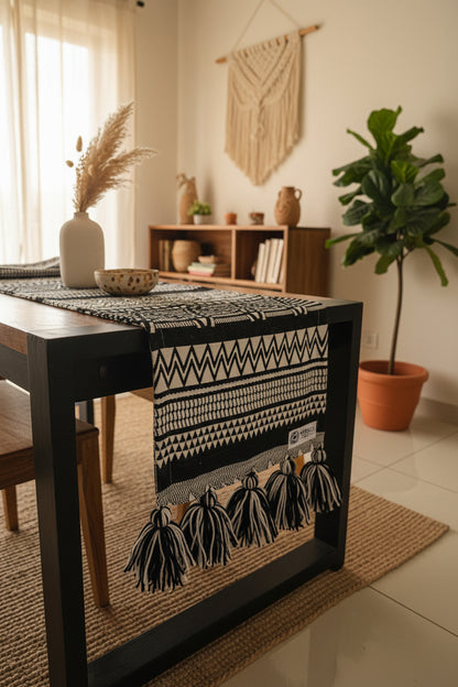 Black and white patterned fabric on a wooden stand with flowers and a rug in the background
