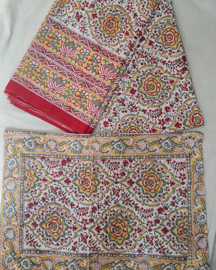 Folded 100x108 inch king size cotton bedsheet and matching pillow covers featuring a traditional red, yellow, and green handblock floral print.