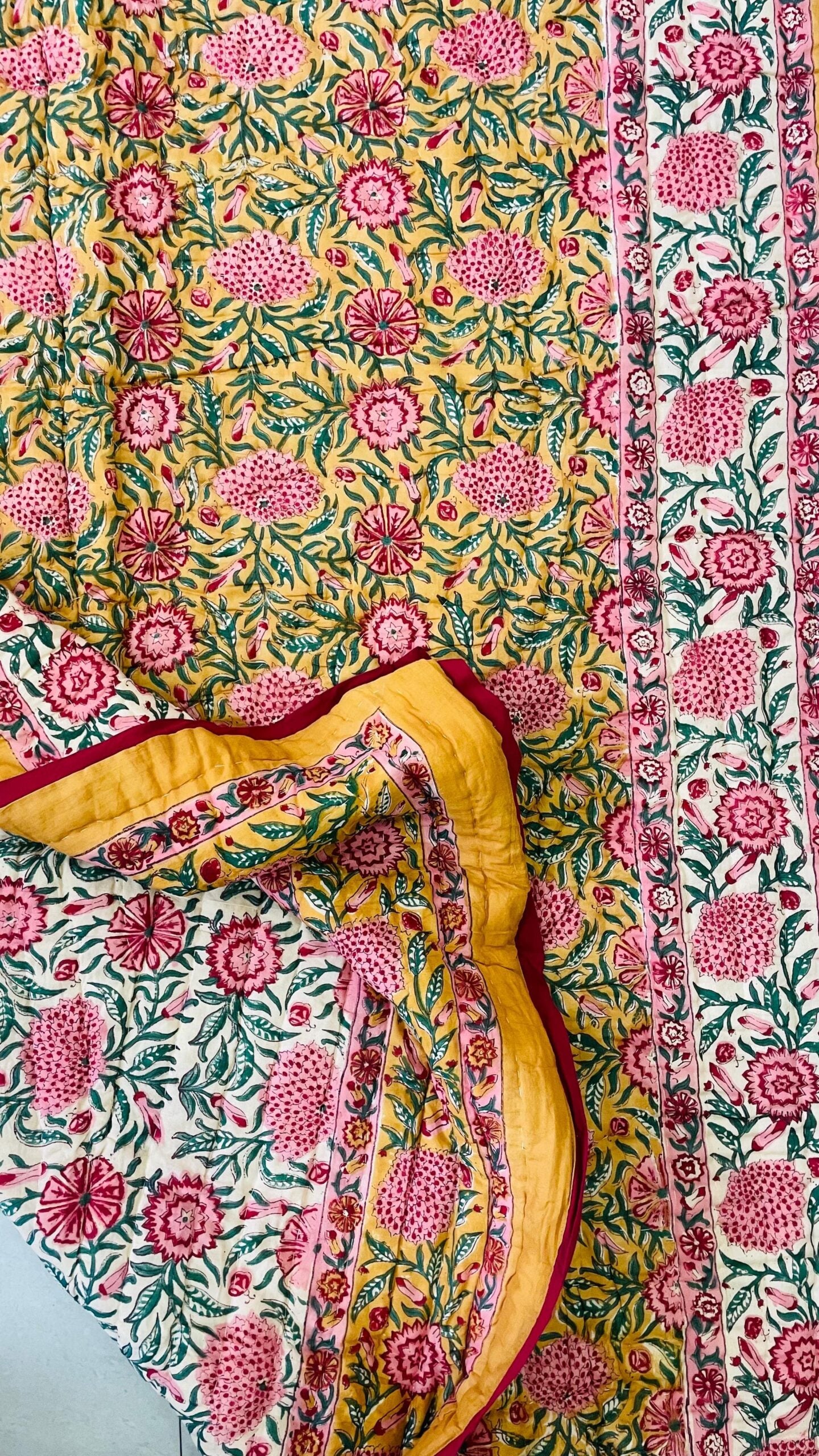 Floral fabric with pink and green pattern on a yellow background