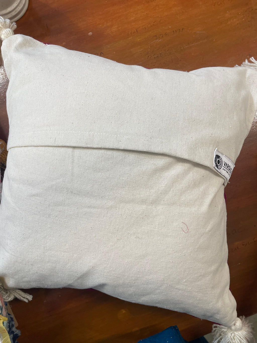 White pillow with a brand label on a wooden surface