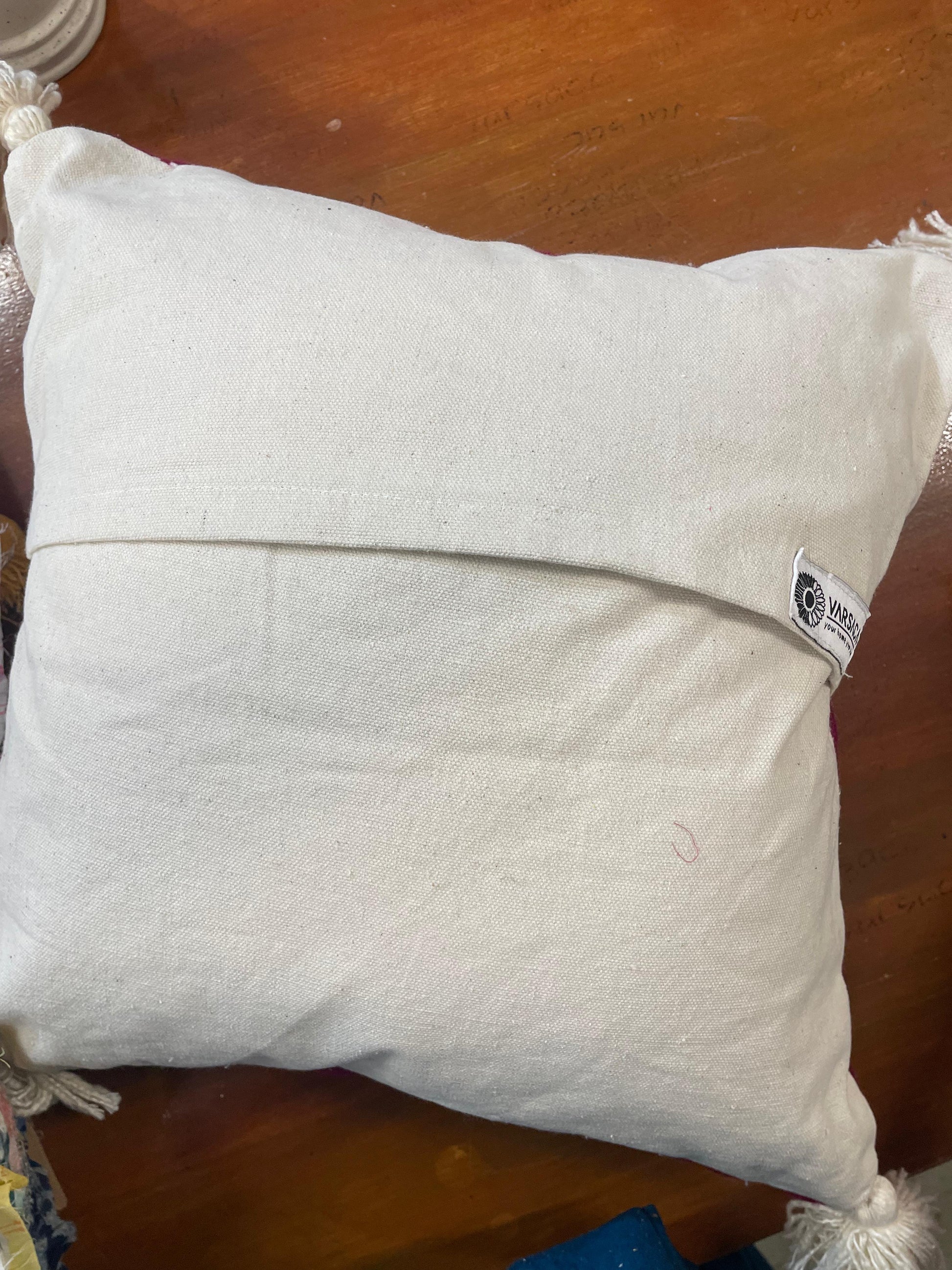 White pillow with a brand label on a wooden surface
