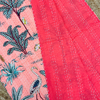 Fabric with tropical pattern featuring birds and plants on a pink background