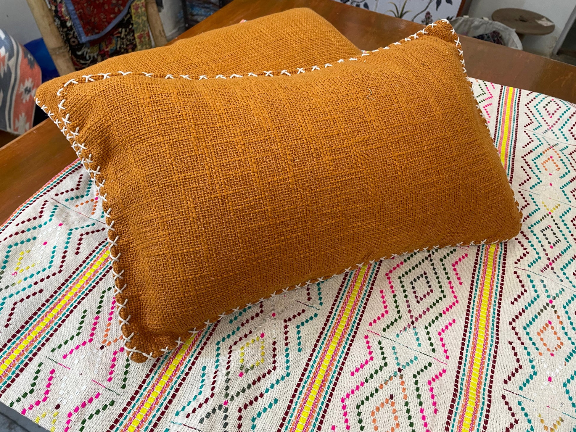 Two orange pillows on a colorful patterned surface