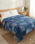 Indigo patchwork kantha cotton quilt featuring an intricate mix of deep blue block-printed geometric and botanical panels with traditional hand-stitching.