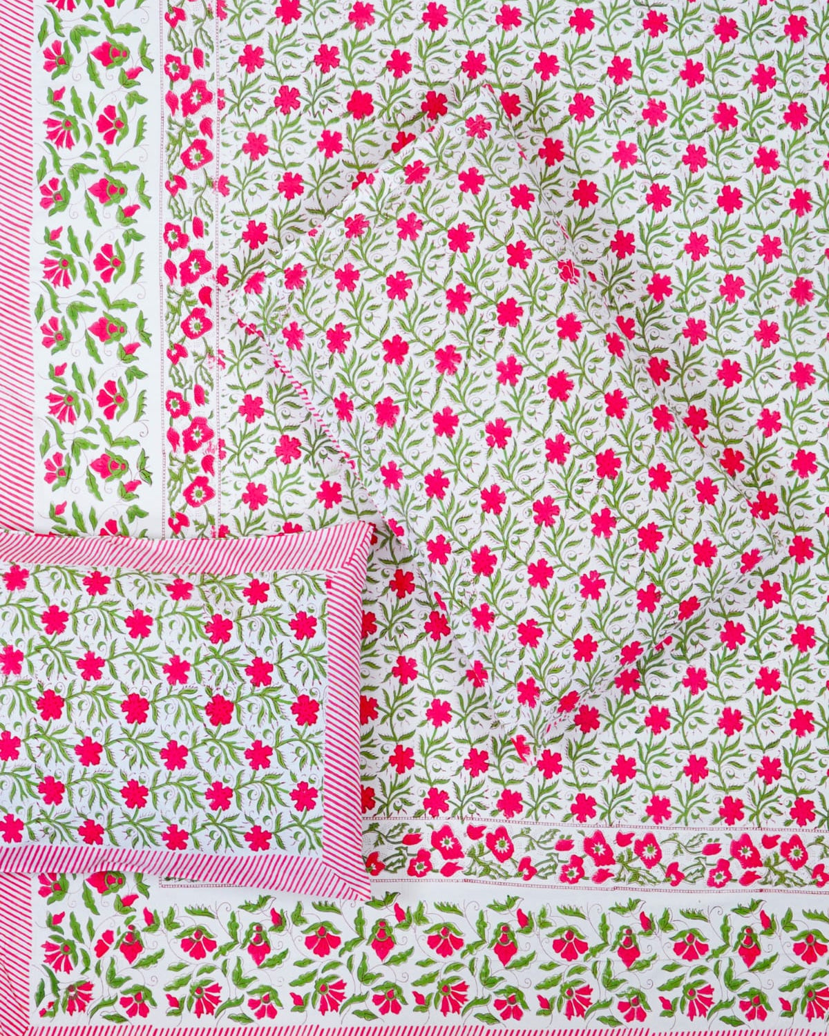 100x108 inch king size cotton bedsheet and matching striped pillow covers styled with a traditional magenta pink and green floral vine handblock print.