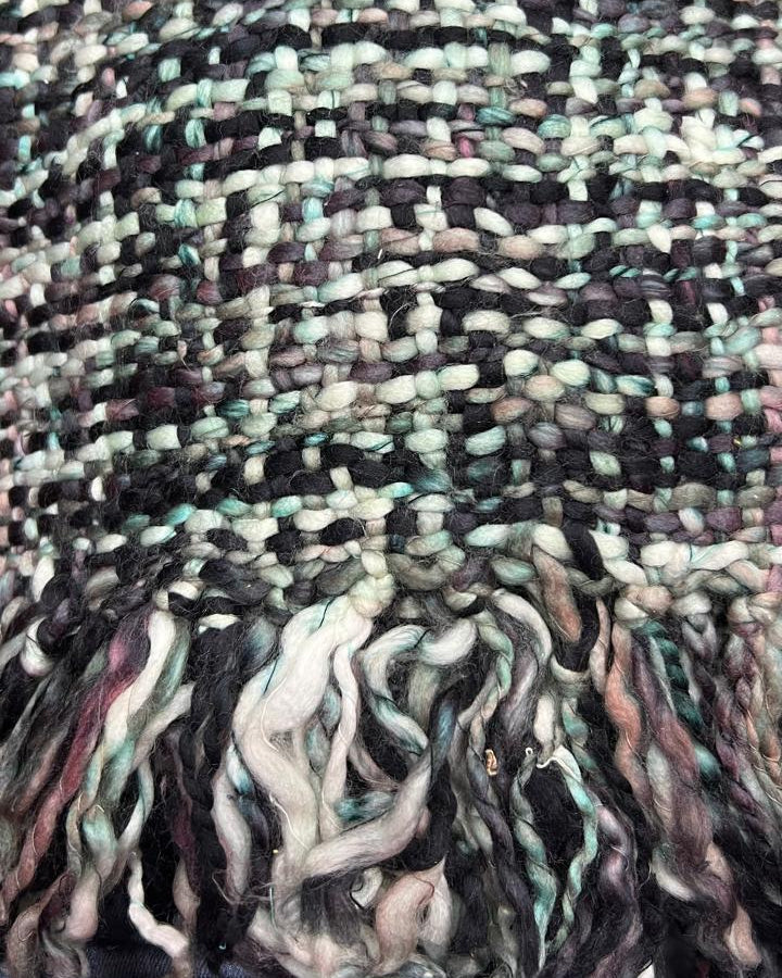 Mint green, blush pink, and charcoal black handwoven chunky woolen sofa throw blanket featuring a textured tweed basketweave and twisted fringe.