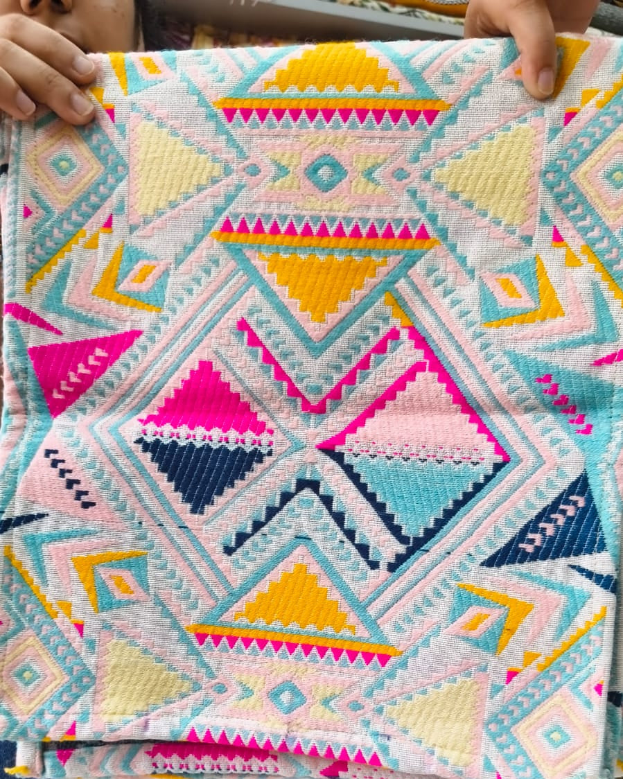Multicolor geometric Jacquard cotton dining table runner featuring vibrant Aztec patterns in hot pink, mustard yellow, and turquoise, with Vasaca brand labels.