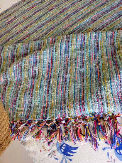Multicolored striped fabric with tassels on a textured surface