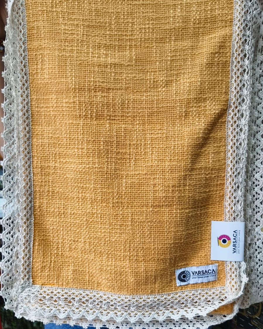 Mustard orange jute-cotton handloom table runner featuring an intricate off-white crochet lace border and Vasaca brand labels.