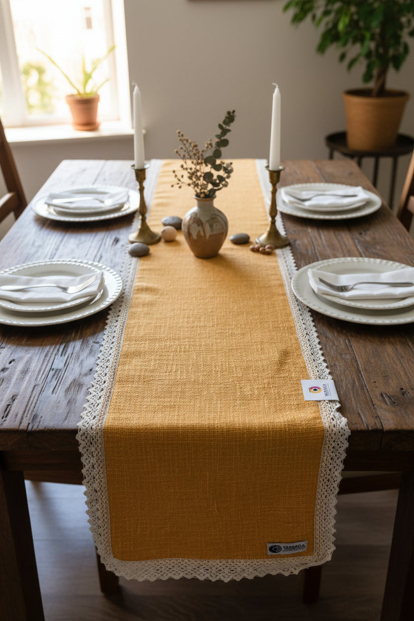 Mustard orange jute-cotton handloom table runner featuring an intricate off-white crochet lace border and Vasaca brand labels.