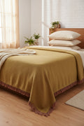 Mustard yellow handloom slub cotton king size bed cover featuring a textured solid weave and handcrafted fringe tassels.