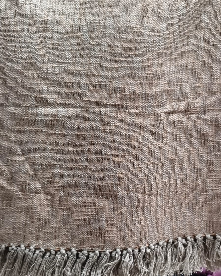 Natural beige handloom slub cotton king size bed cover featuring an earthy textured solid weave and handcrafted fringe tassels.