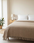 Natural beige handloom slub cotton king size bed cover featuring an earthy textured solid weave and handcrafted fringe tassels.