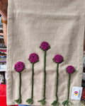 Natural beige jute-cotton handloom table runner featuring handcrafted 3D magenta flower embroidery with green stems, with a Vasaca brand label.