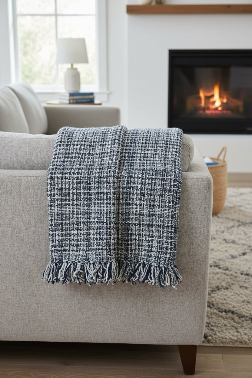 Navy and sky blue handwoven chunky woolen sofa throw blanket featuring a textured windowpane grid plaid pattern and twisted fringe tassels.