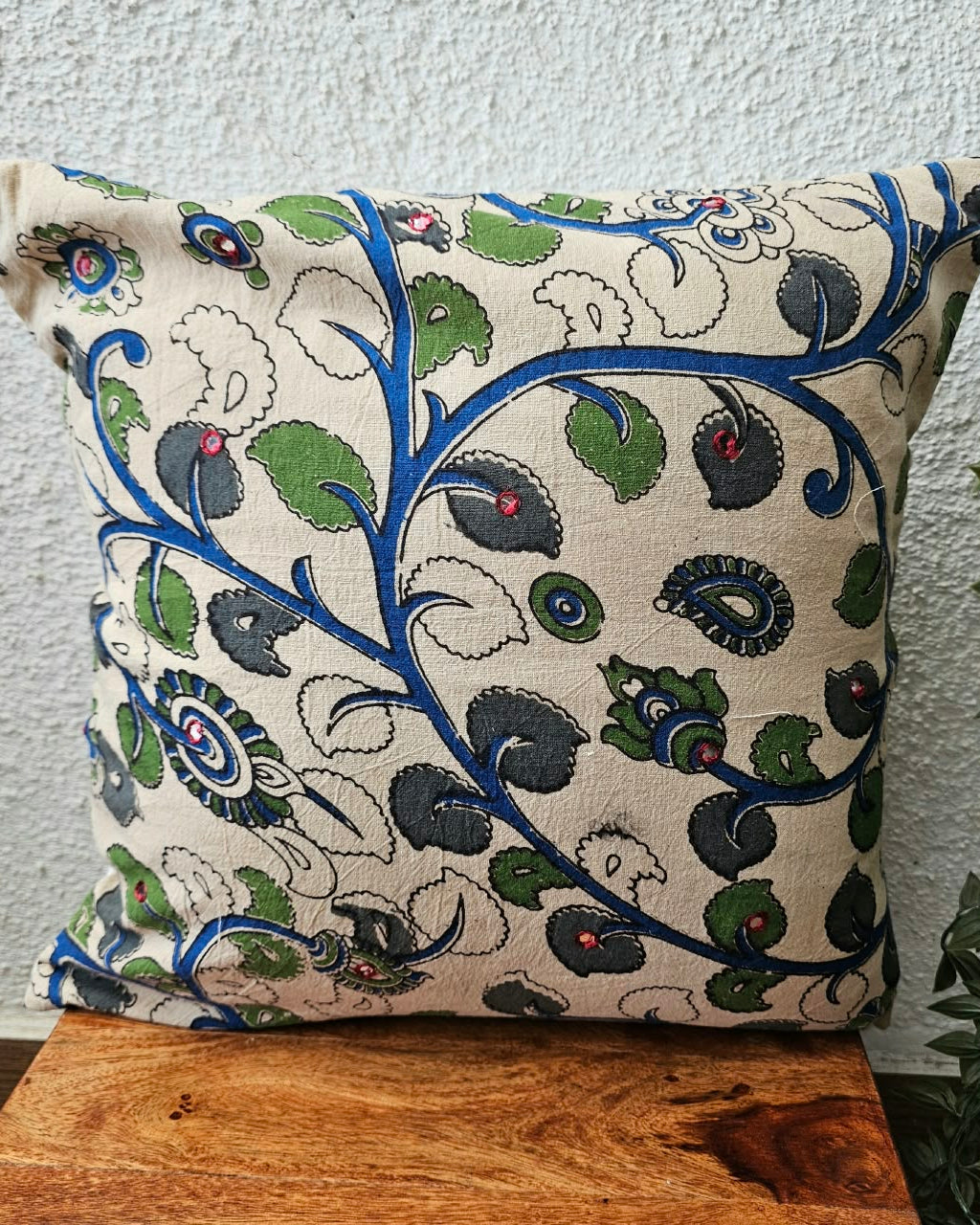 Natural off-white cotton cushion cover featuring traditional blue and green handblock floral vine prints with subtle accent embellishments.