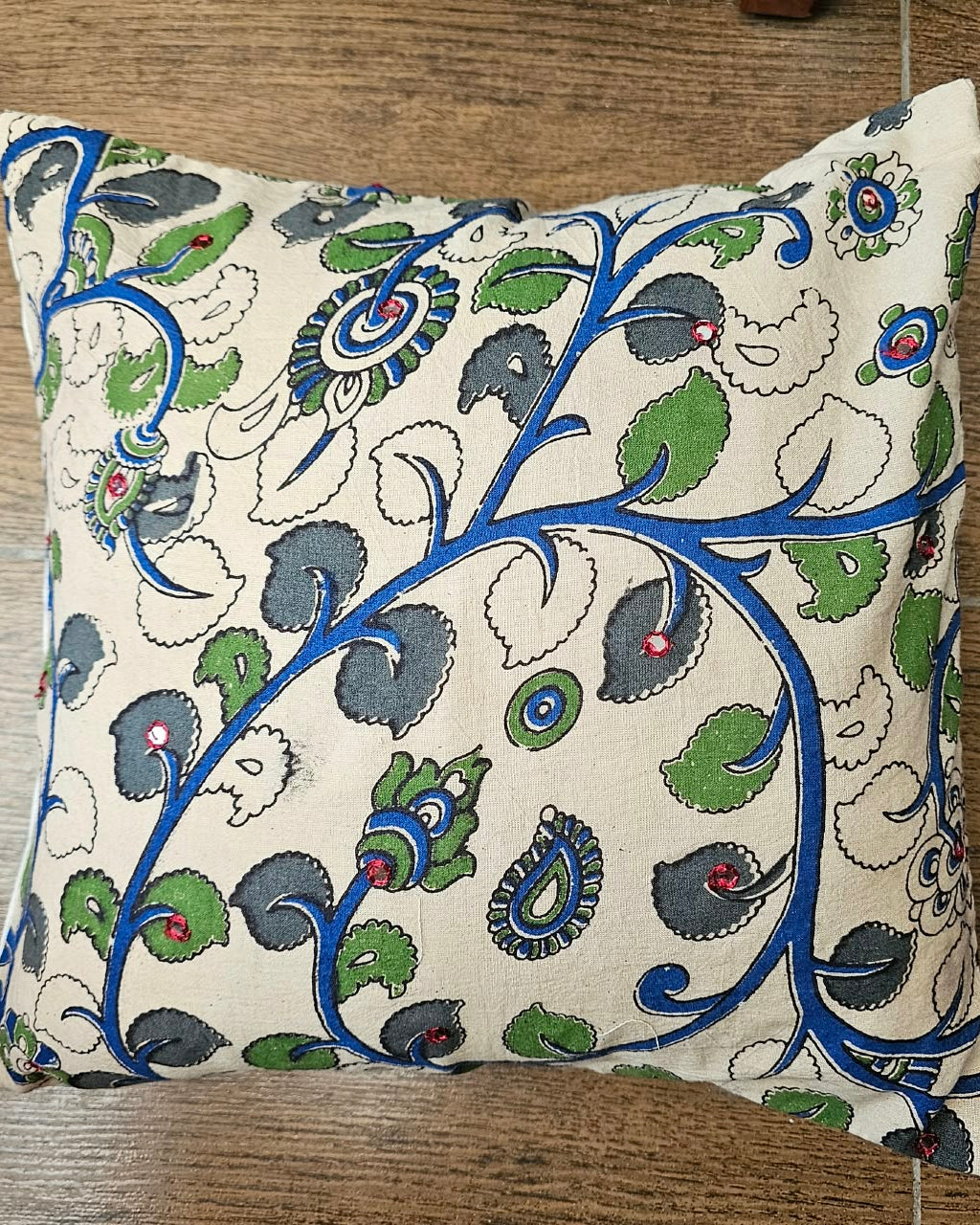 Natural off-white cotton cushion cover featuring traditional blue and green handblock floral vine prints with subtle accent embellishments.