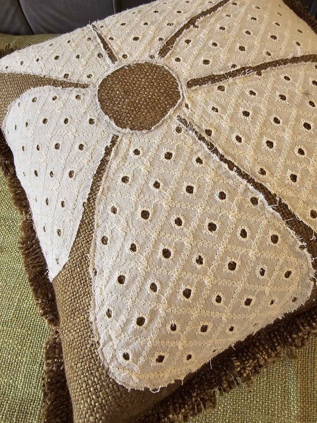 Close-up of a textured fabric with a floral pattern on a green background
