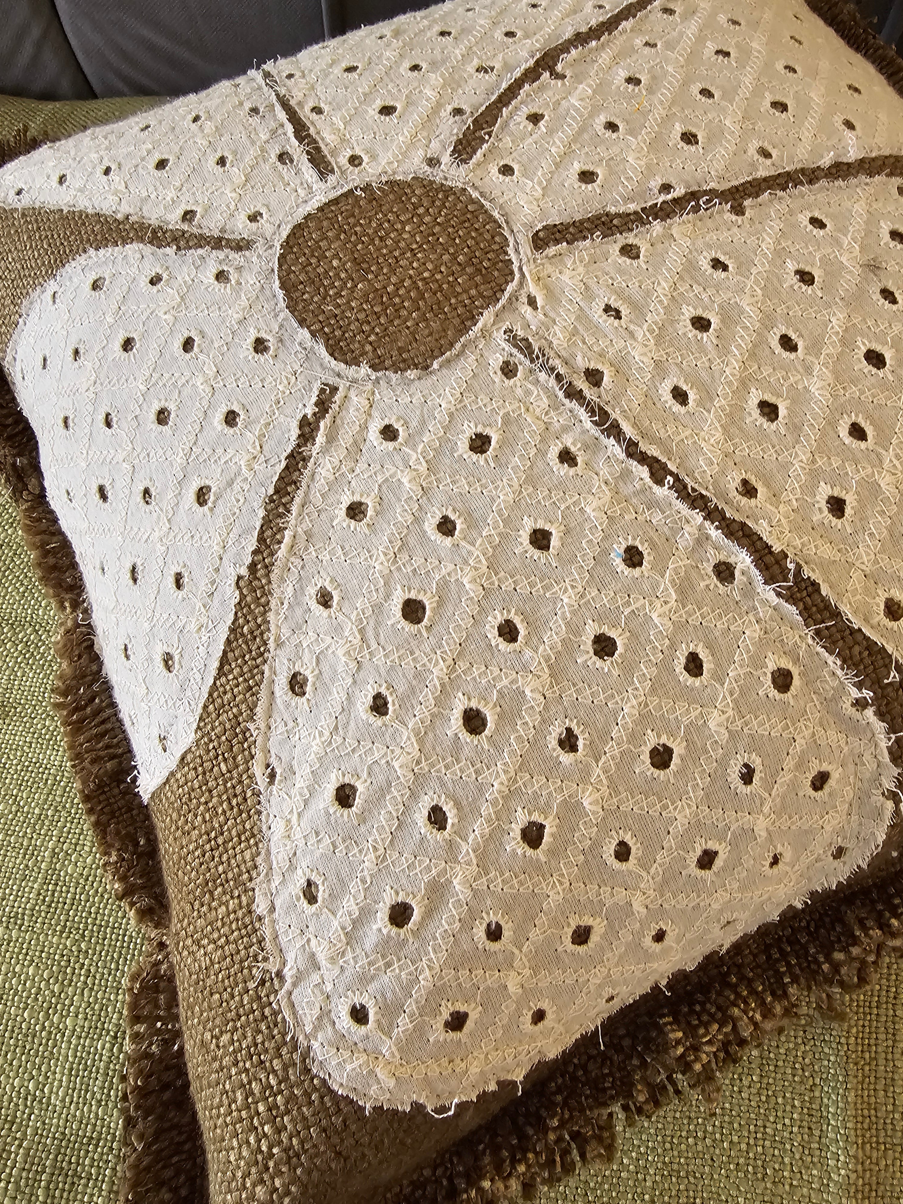 Close-up of a textured fabric with a floral pattern on a green background