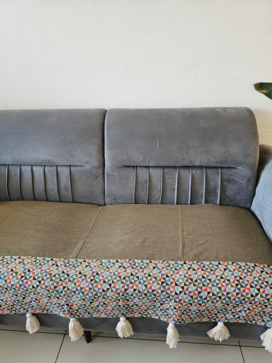 Gray textured wall with a patterned fabric strip hanging on it